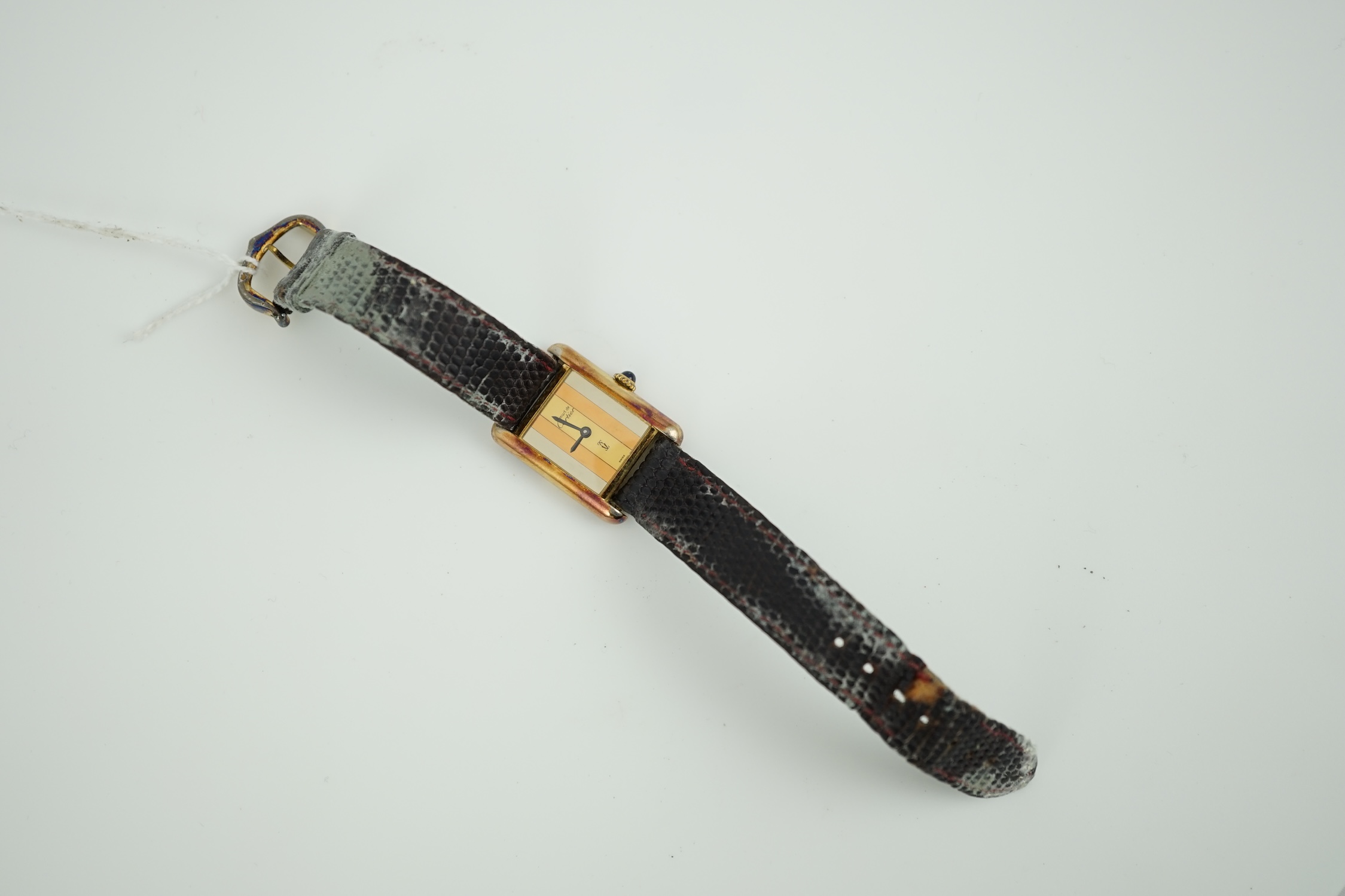 A lady's silver gilt Must De Cartier rectangular dial manual wind wrist watch, case diameter 20mm, on a leather strap.